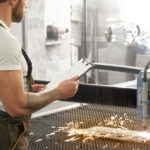 Engineer controlling plasma laser cutting metal.